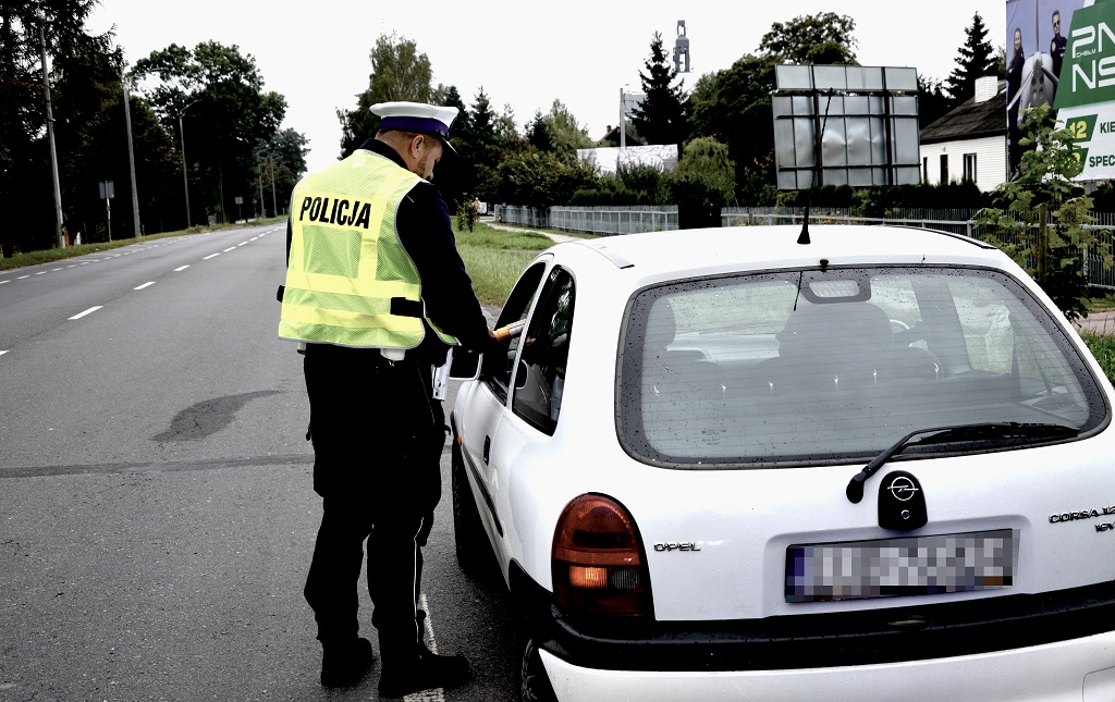 policjant sprawdza stan trzeźwości kierującej oplem