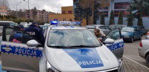 Policjanci wspólnie z dziećmi przy radiowozie