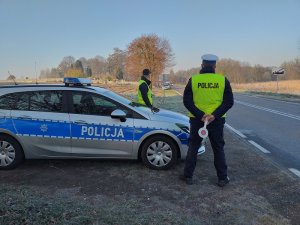 policjant stojący obok radiowozu