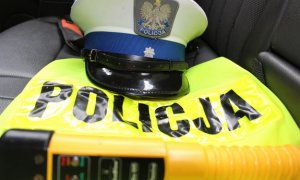 czapka policyjna leżąca na kamizelce odblaskowej z napisem POLICJA