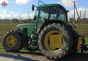 ciągnik rolniczy marki john deere stojący na poboczu