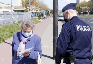 zdjęcie przedstawia umundurowanego policjanta i osobę pieszą z maseczka ochronną