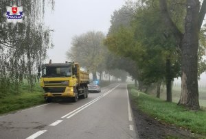 na poboczu stoi uszkodzony pojazd ciężarowy marki Man, a za nim radiowóz policyjny