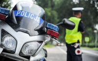 policjant i motocykl stoją na drodze