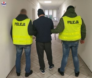 policjanci prowadzą zatrzymanego numer 3