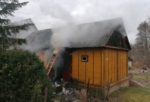 strażak gasi pożar budynku mieszkalnego