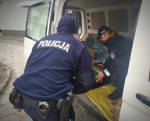 policjanci ustawiają towary w samochodzie