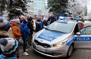 dzieci razem z policjantem oglądają radiowóz