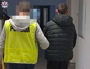 policjant prowadzi zatrzymanego