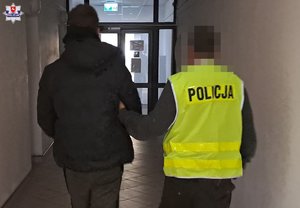 policjant prowadzi zatrzymanego