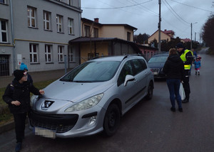 policjant kieruje samochody przed szkołą