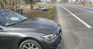na zdjęciu widać radiowóz nieoznakowany Policji, a w tle rozbity samochód marki Audi