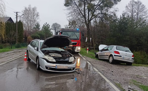 na zdjęciu widać dwa rozbite pojazdy stojące na drodze