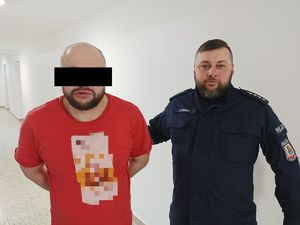 zatrzymany mężczyzna prowadzony przez policjanta