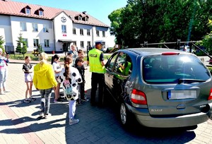 policjant wspólnie z dziećmi kontroluje pojazd