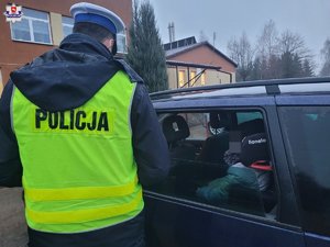 policjant ruchu drogowego kontroluje pojazd