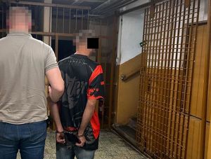 policjant prowadzi zatrzymanego