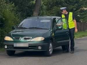 policjant kontrolujący trzeźwość kierowcy