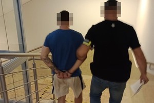 zatrzymany prowadzony przez policjanta