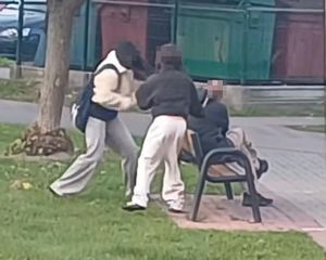 dwie nastolatki przy ławce na której siedzi meżczyzna