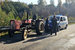 Policjantka i strażnik leśny z nietrzeźwym kierującym ciągnikiem.