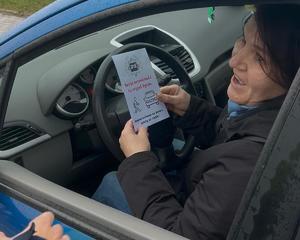 kierowca trzyma w ręku ulotkę