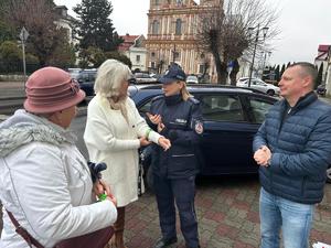 radni i policjantka rozdają odblaski