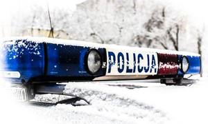 ośnieżony dach radiowozu z sygnałami świetlnymi z napisem Policja