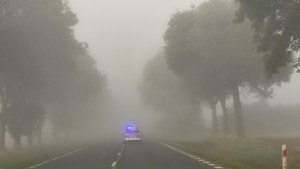 radiowóz na drodze we mgle