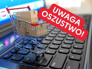 wózek sklepowy na klawiaturze komputera. Wyżej napis "Uwaga oszustwo"