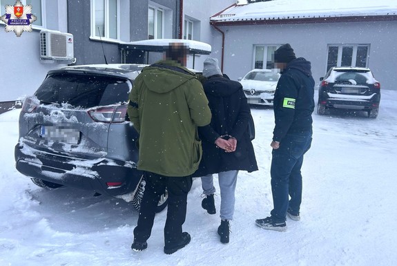 zatrzymana kobieta prowadzona przez nieumundurowanych policjantów