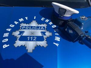 czapka policjanta ruchu drogowego i urządzenie do pomiaru prędkości na masce radiowozu