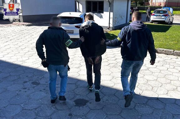 zatrzymany prowadzony przez dwóch nieumundurowanych policjantów