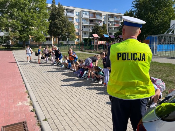 policjant stoi przy grupie dzieci z przedszkola