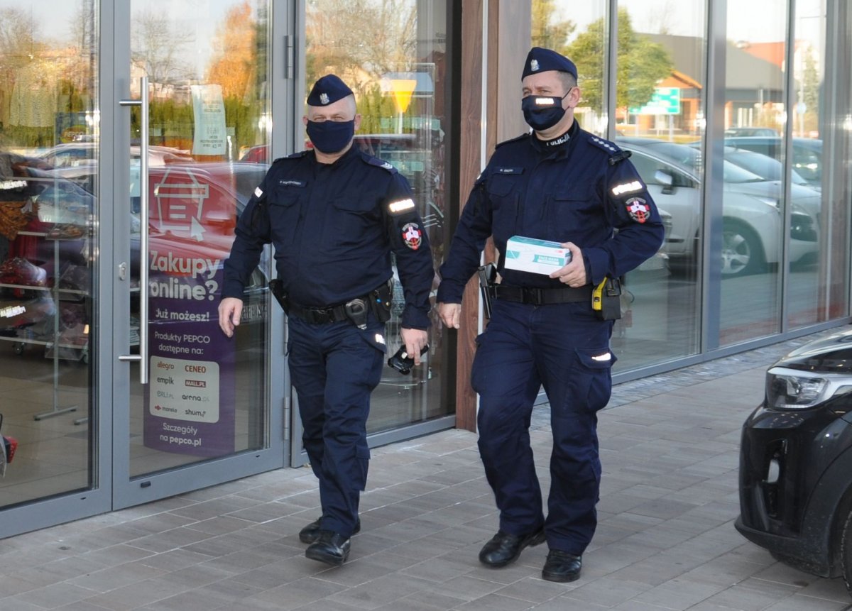 policjanci rozdają maseczki w sklepie