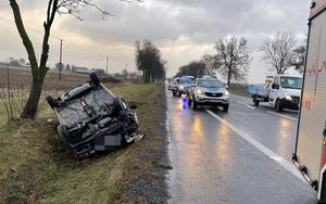 samochód w rowie na dachu. W tle pojazdy służb